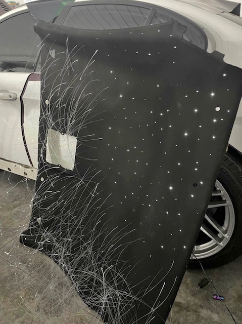 Car headliner drilled and fitted with fiber-optic star strands